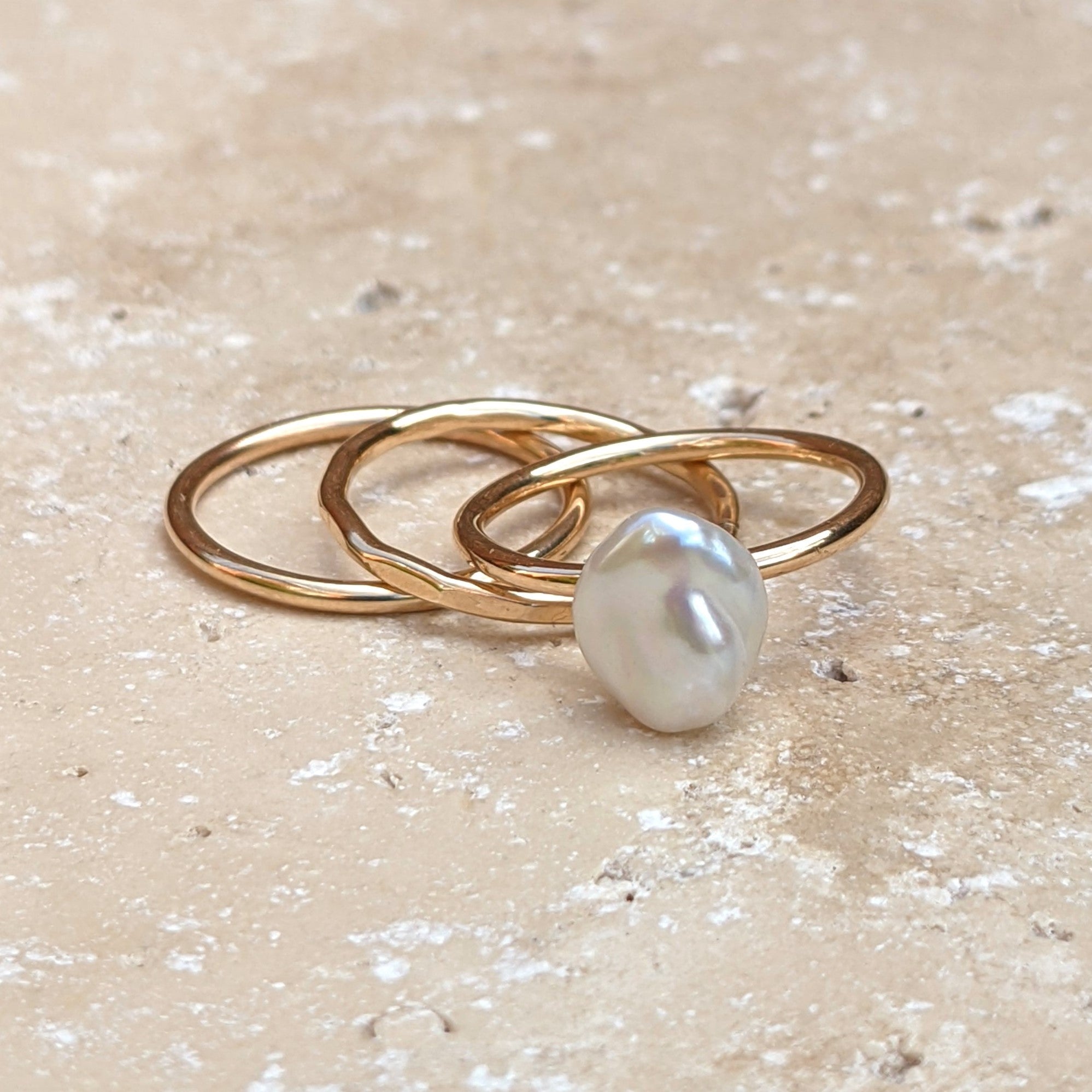 A trio of gold filled stacking rings - plain, hammered and pearl