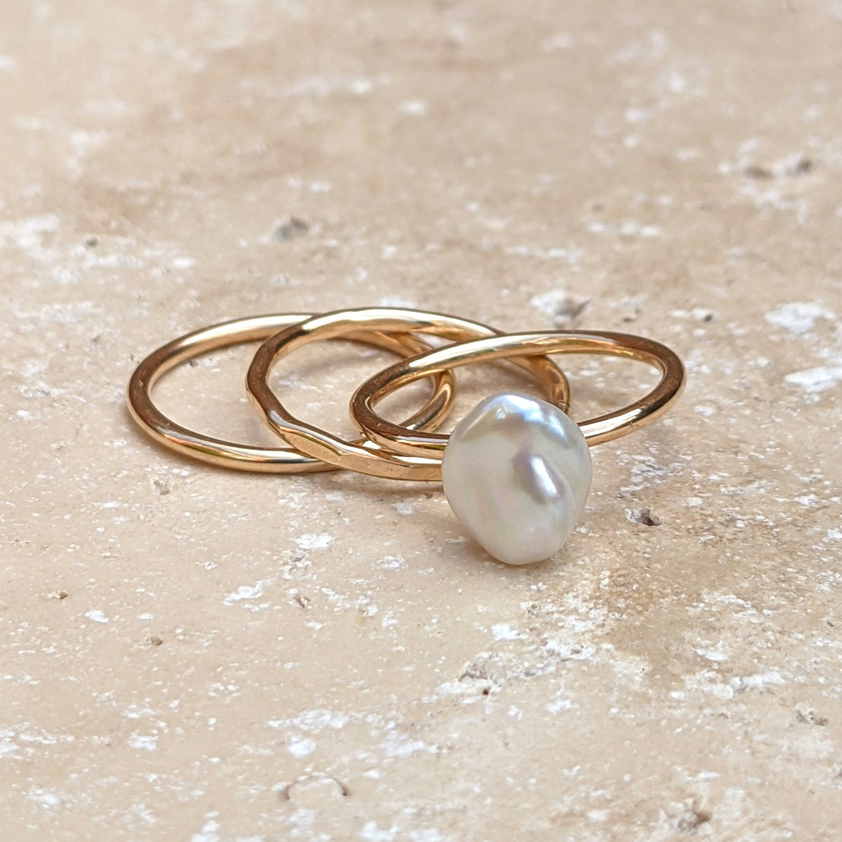 Set of three gold rings - plain hammered and pearl
