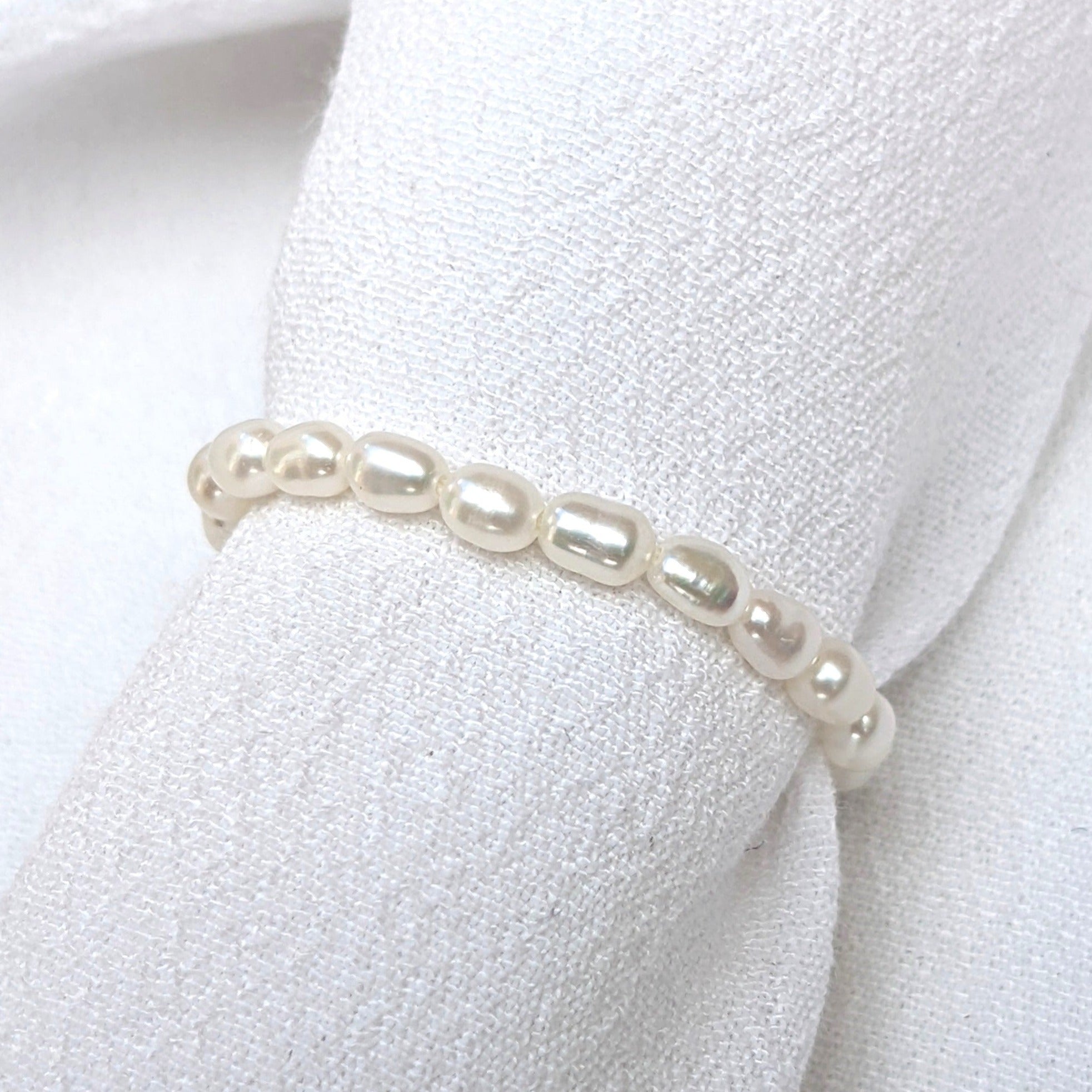 Seed pearl ring on white fabric