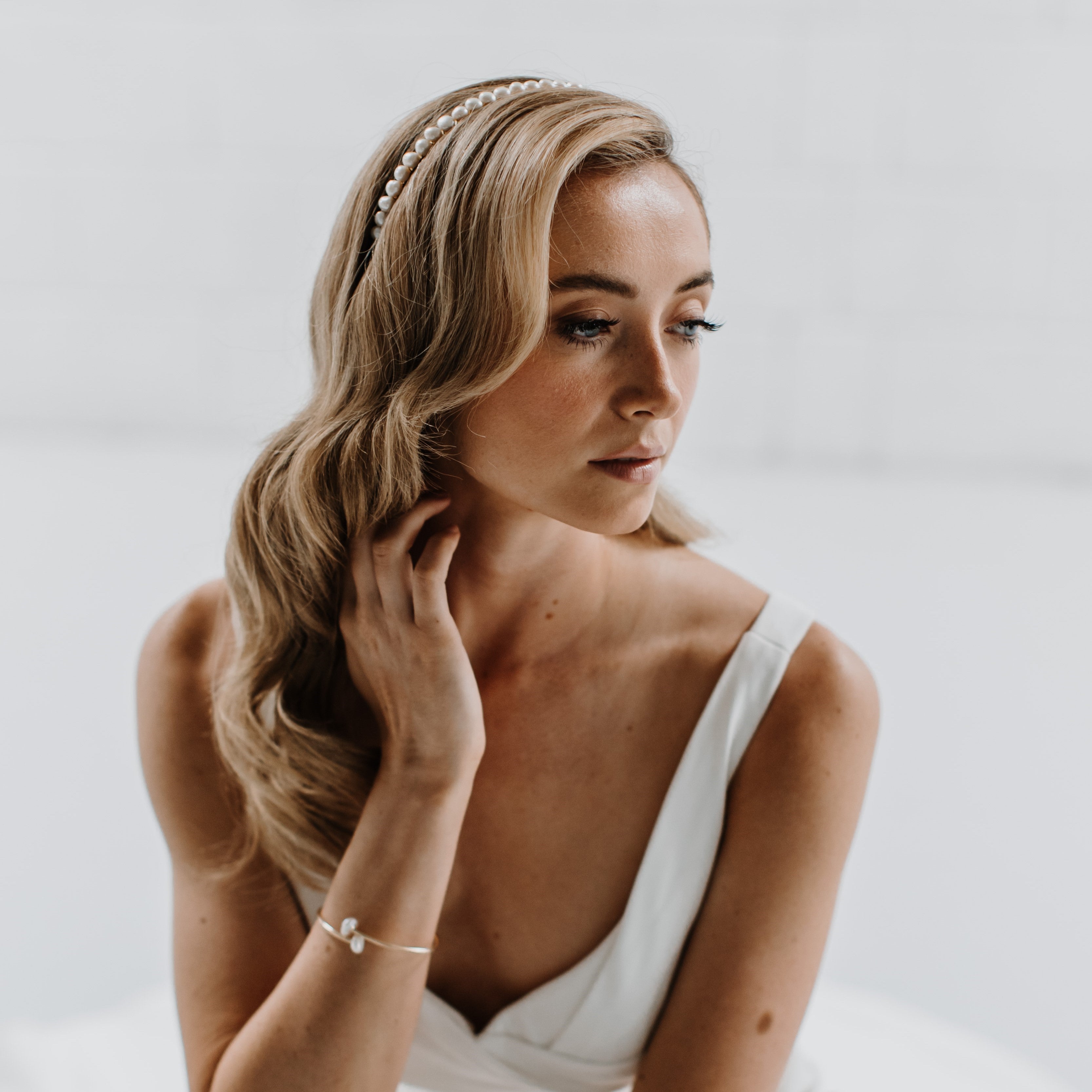 Side view of model wearing a pearl metal headband