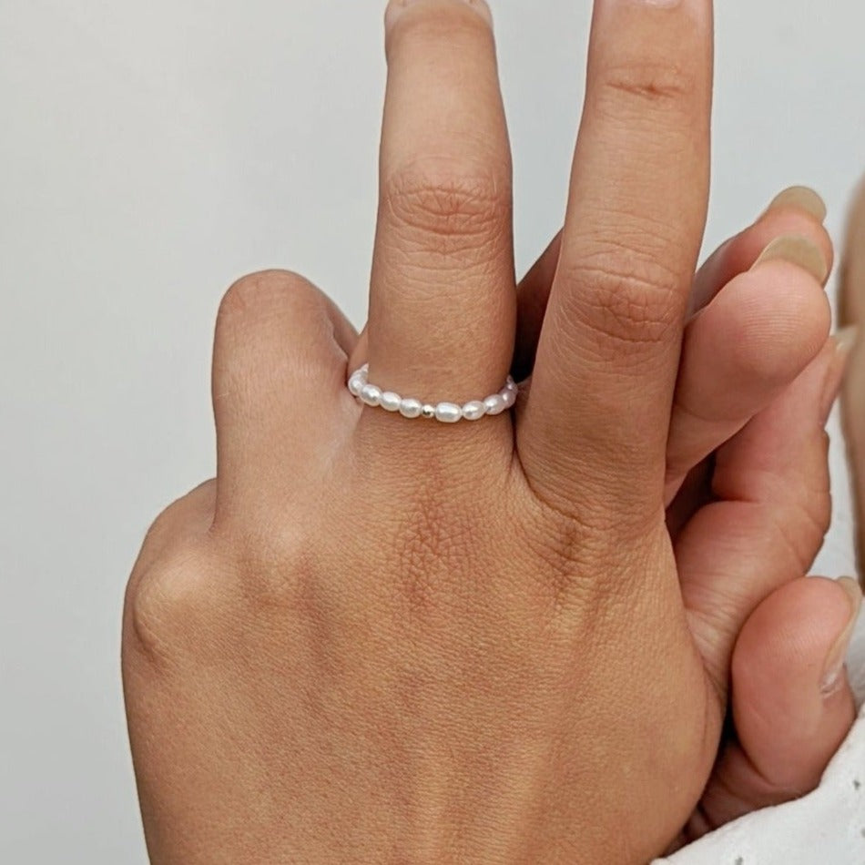 Model wearing pearl necklace and ring